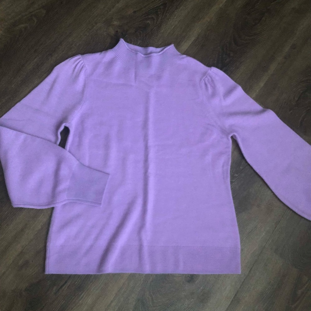 New! A pretty neckline and sleeves elevate this must-have  sweater.